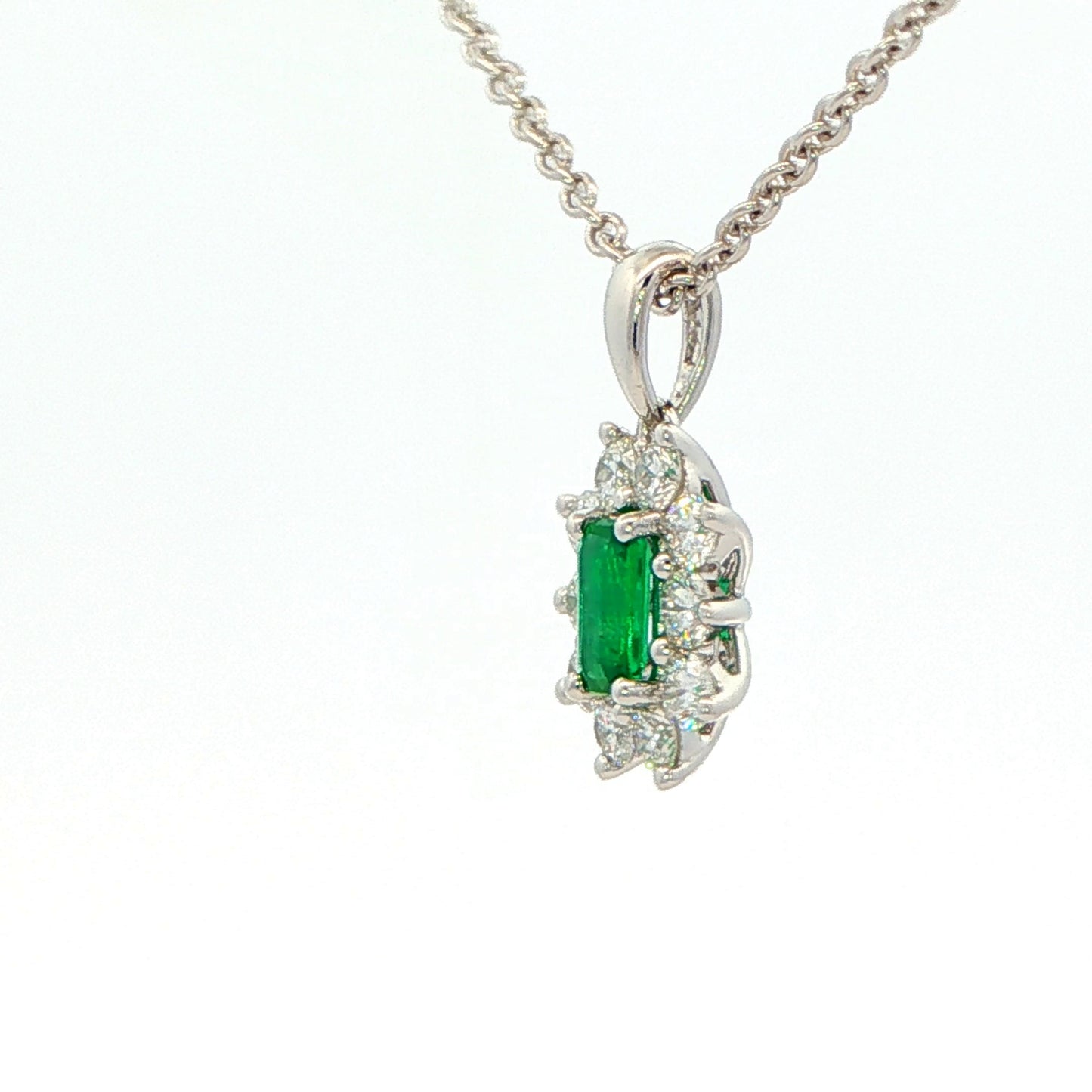 Octagonal shaped emerald and round brilliant cut diamond cluster pendant