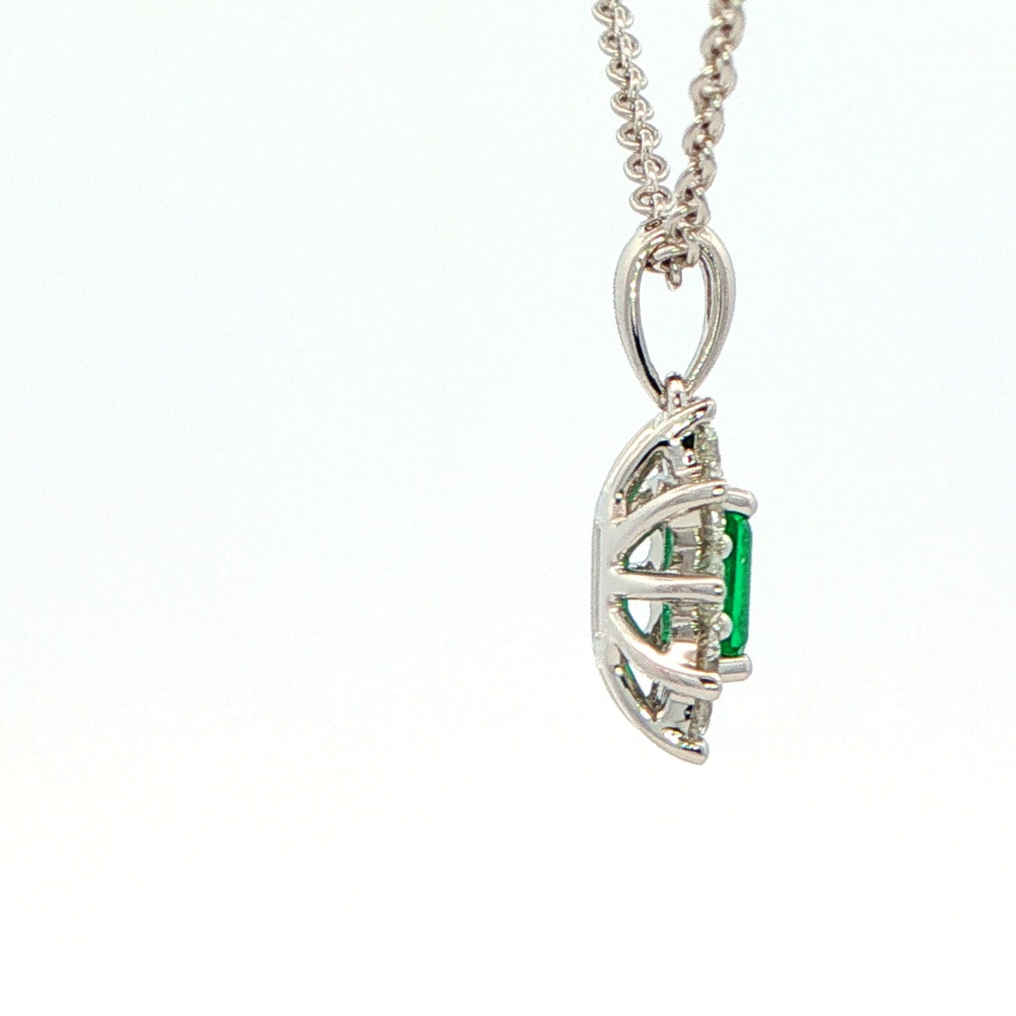 Octagonal shaped emerald and round brilliant cut diamond cluster pendant