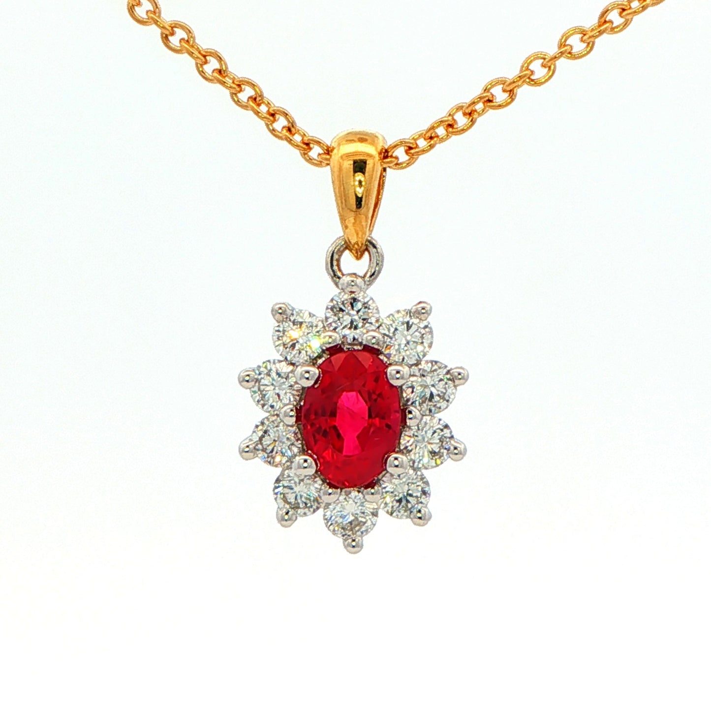 Oval shaped ruby and round brilliant cut diamond cluster style pendant