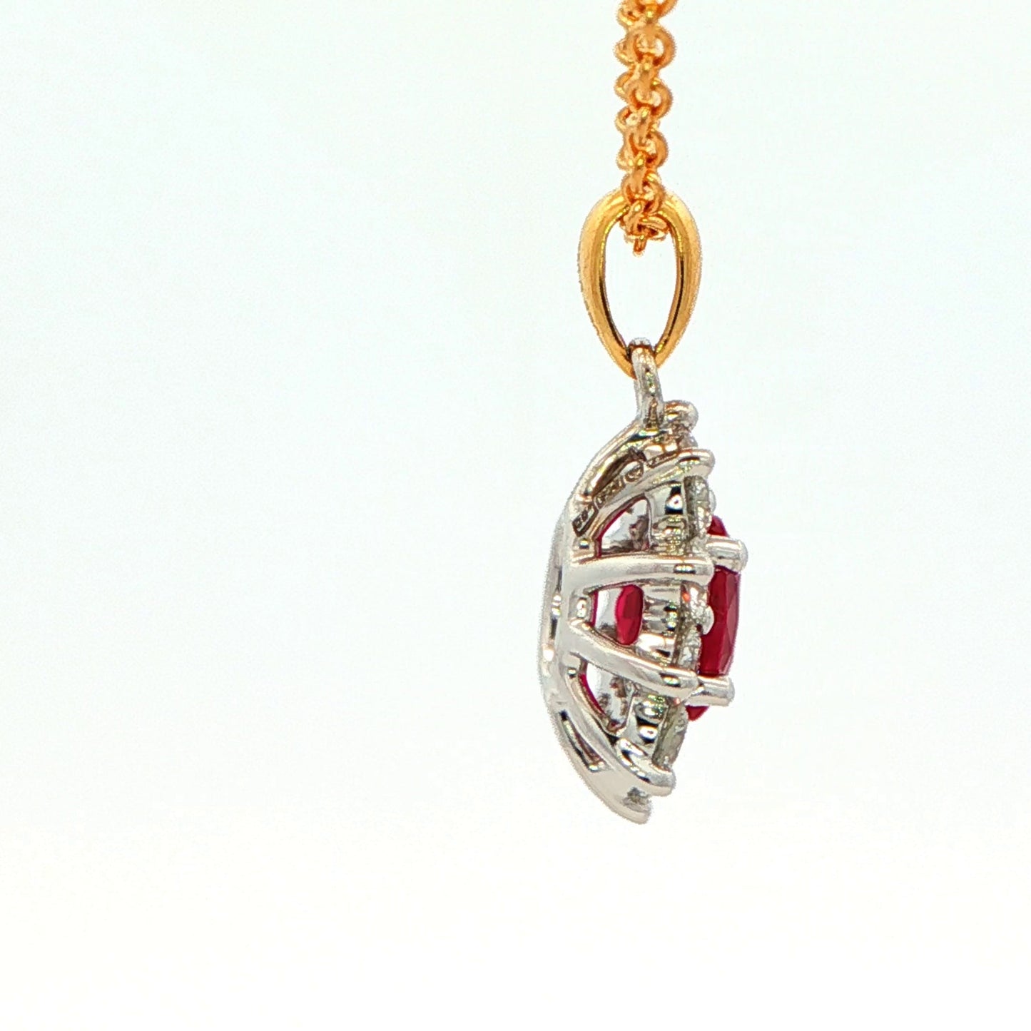 Oval shaped ruby and round brilliant cut diamond cluster style pendant
