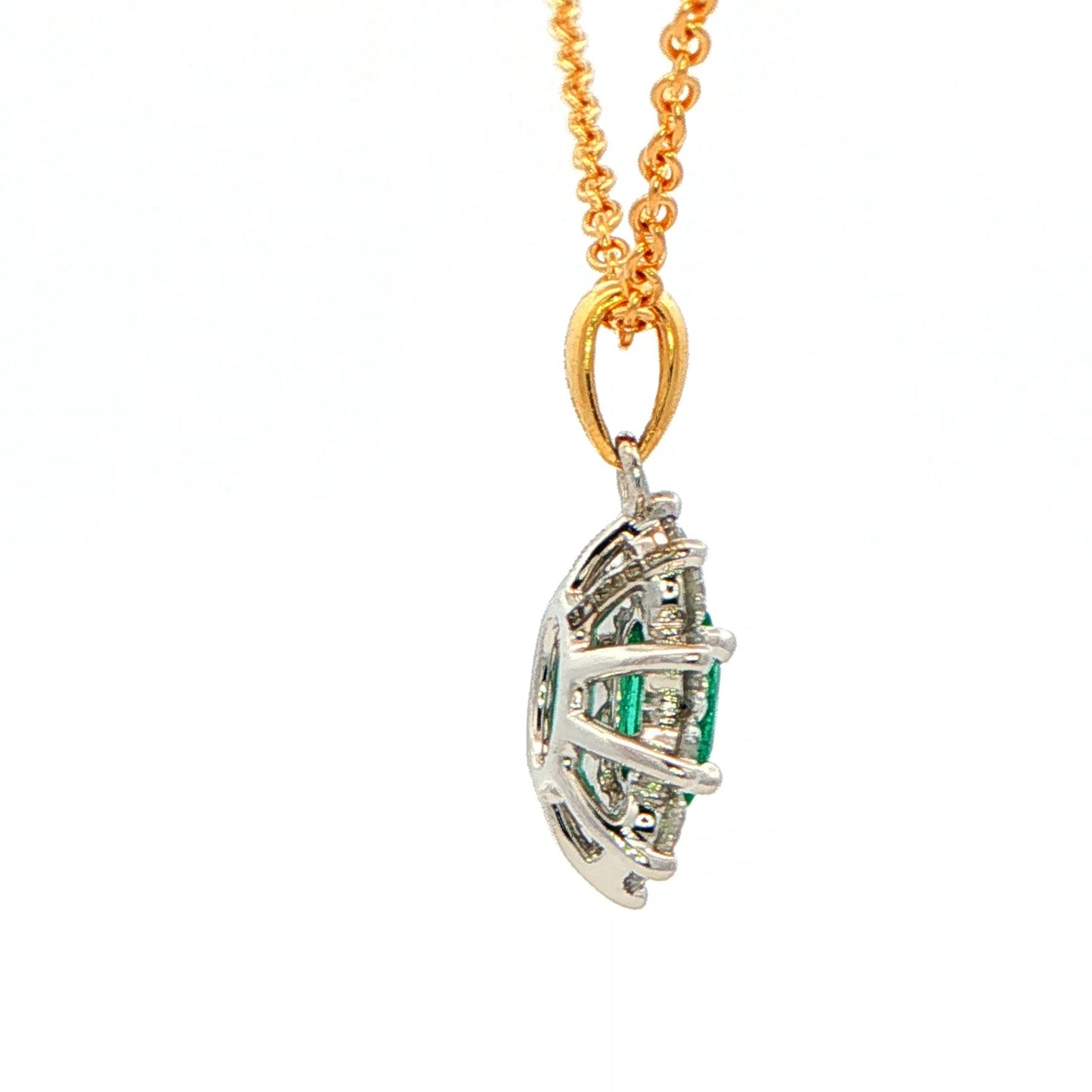 Oval shaped emerald and round brilliant cut diamond cluster style pendant