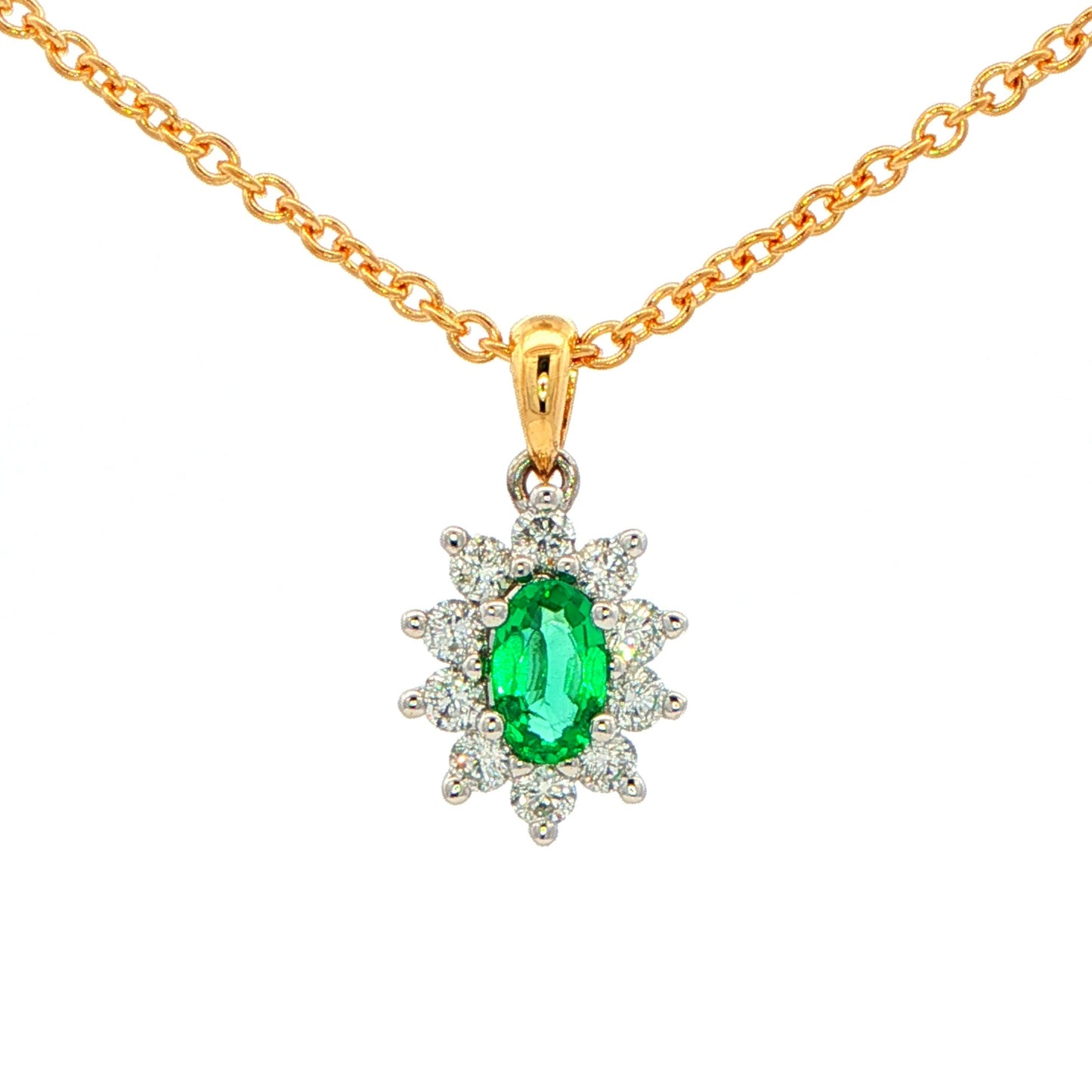 Oval shaped emerald and round brilliant cut diamond cluster style pendant