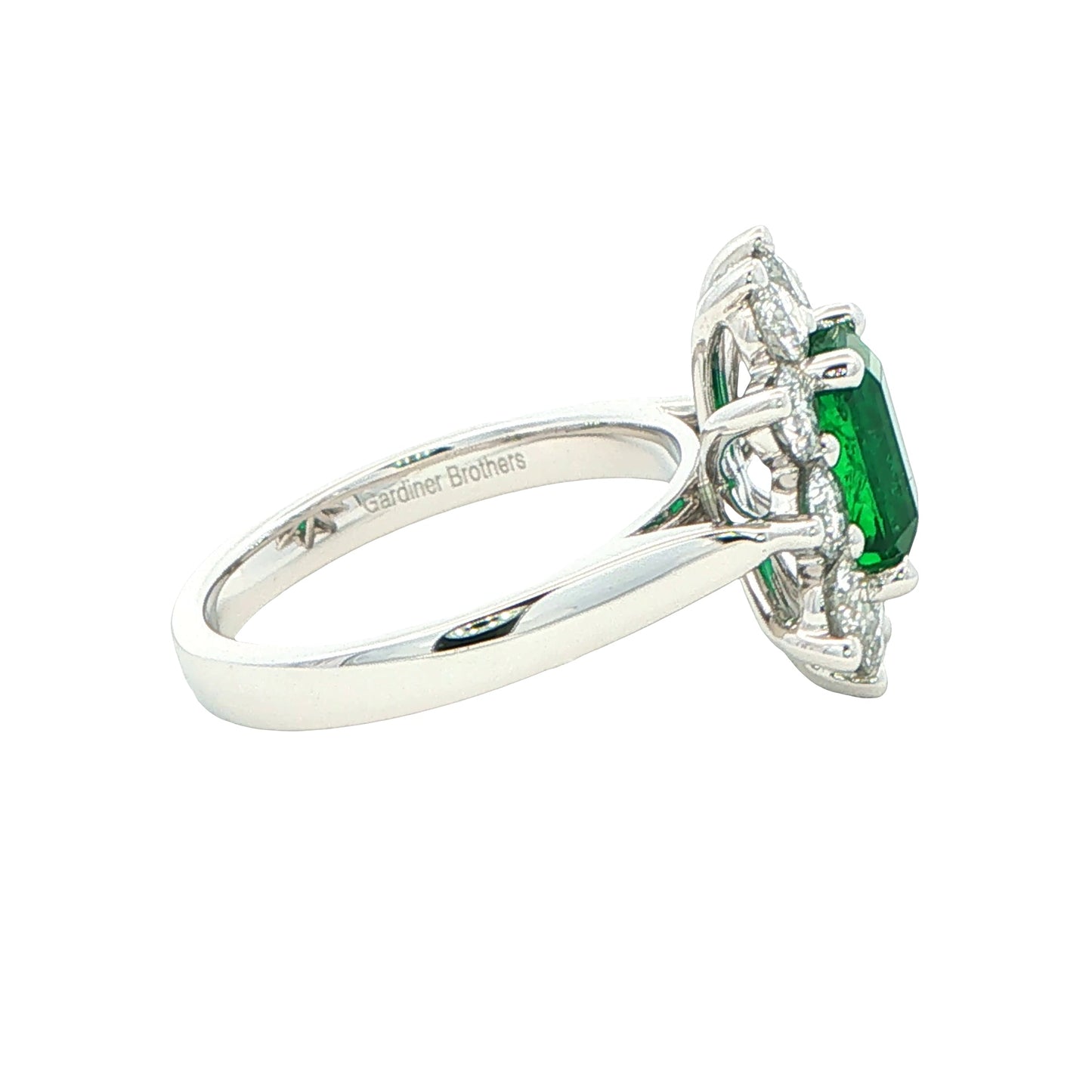Octagonal shaped emerald and round brilliant cut diamond cluster style ring Gardiner Brothers