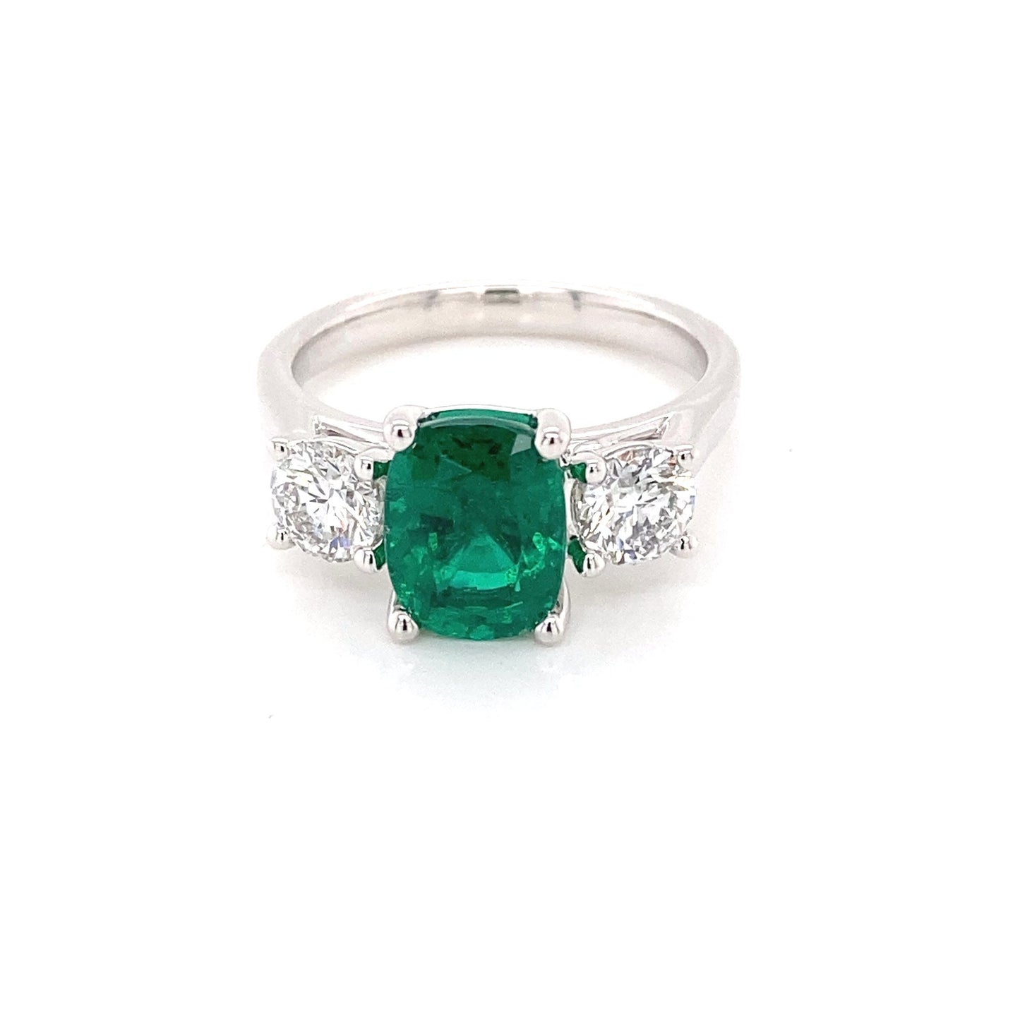 Cushion shaped emerald and round brilliant cut diamond 3 stone ring Gardiner Brothers