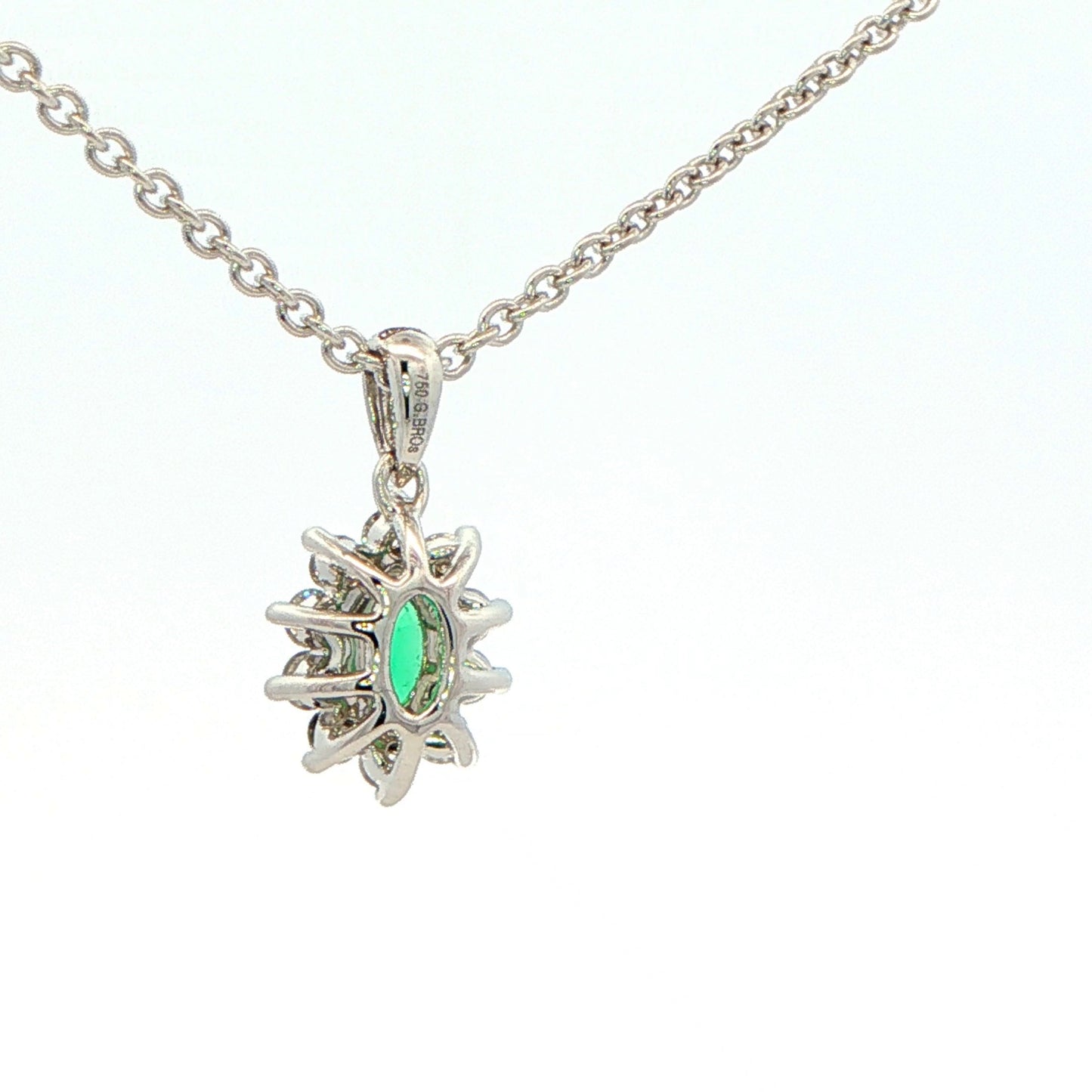 Oval Shaped emerald and round brilliant cut diamond cluster pendant