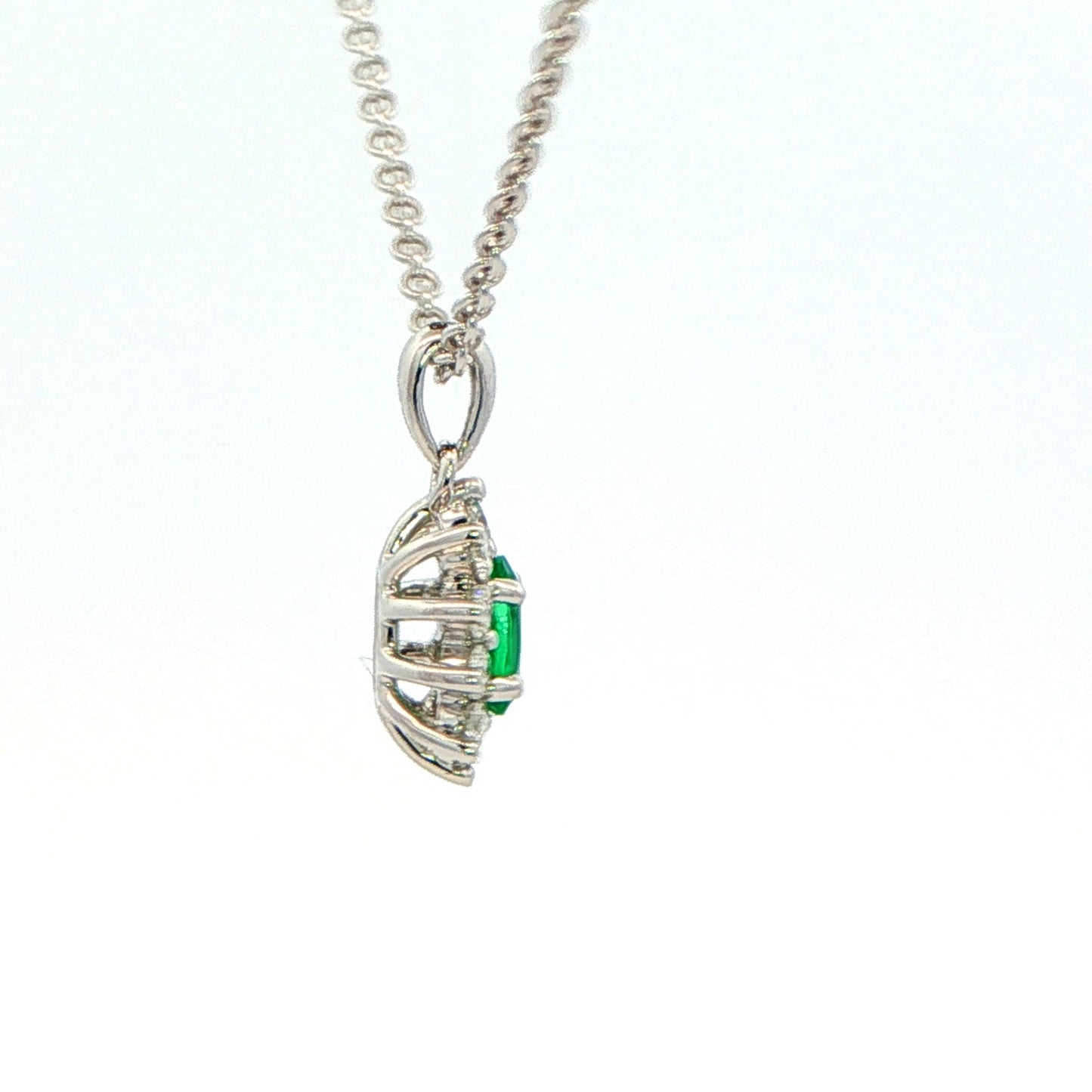 Oval Shaped emerald and round brilliant cut diamond cluster pendant