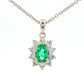 Oval shaped emerald and round brilliant cut diamond cluster pendant