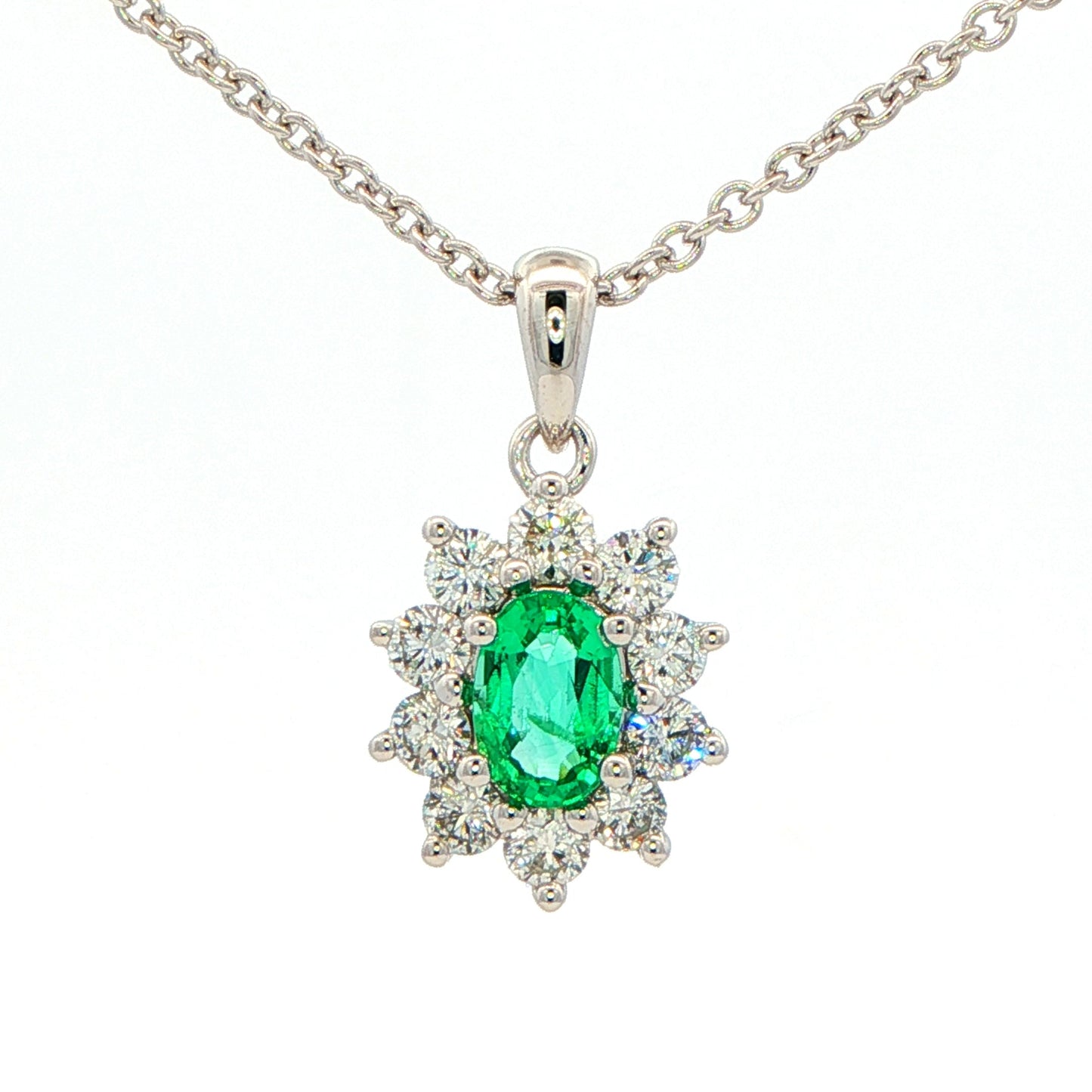 Oval shaped emerald and round brilliant cut diamond cluster pendant