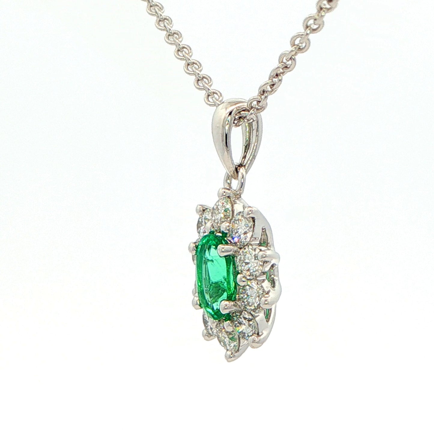 Oval shaped emerald and round brilliant cut diamond cluster pendant