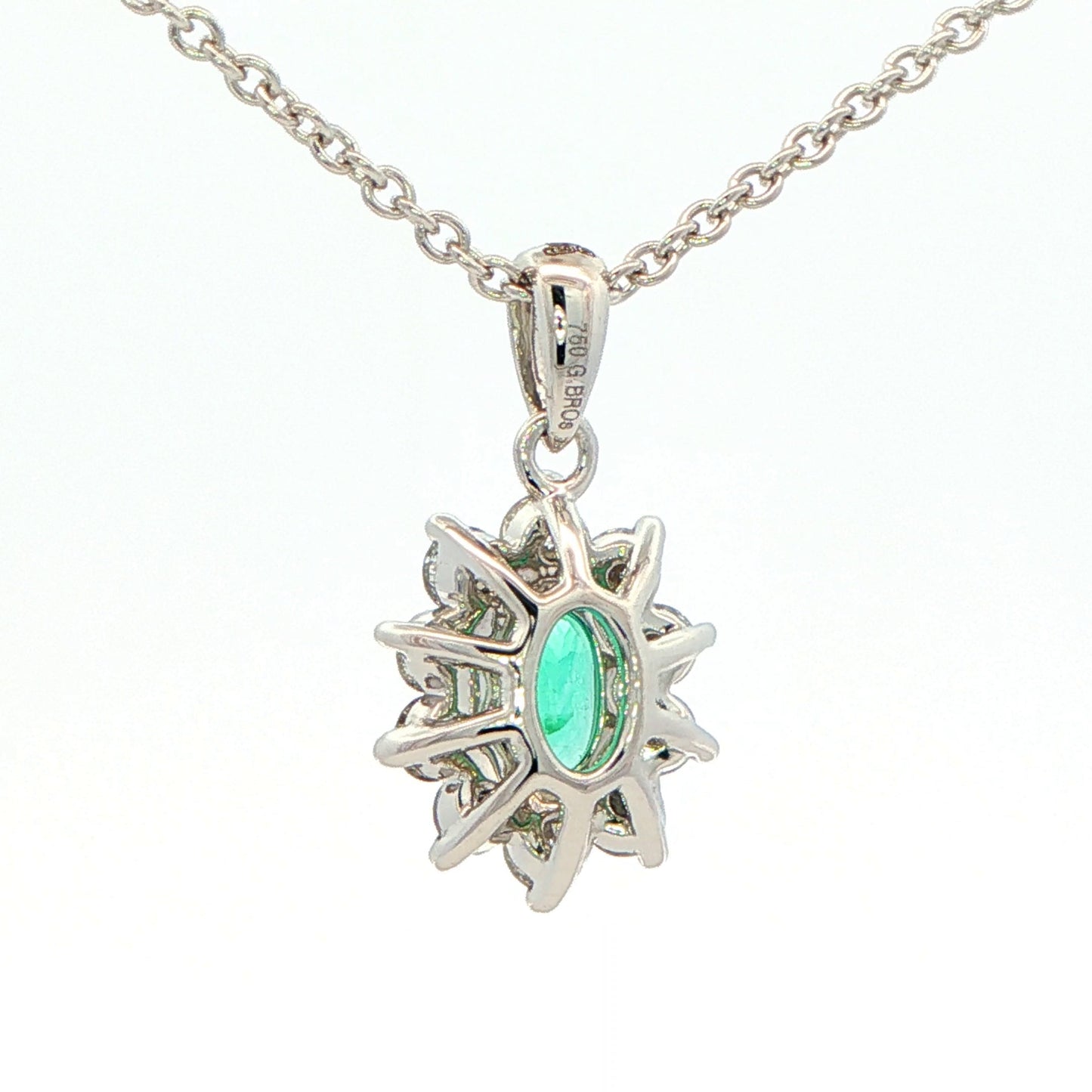 Oval shaped emerald and round brilliant cut diamond cluster pendant