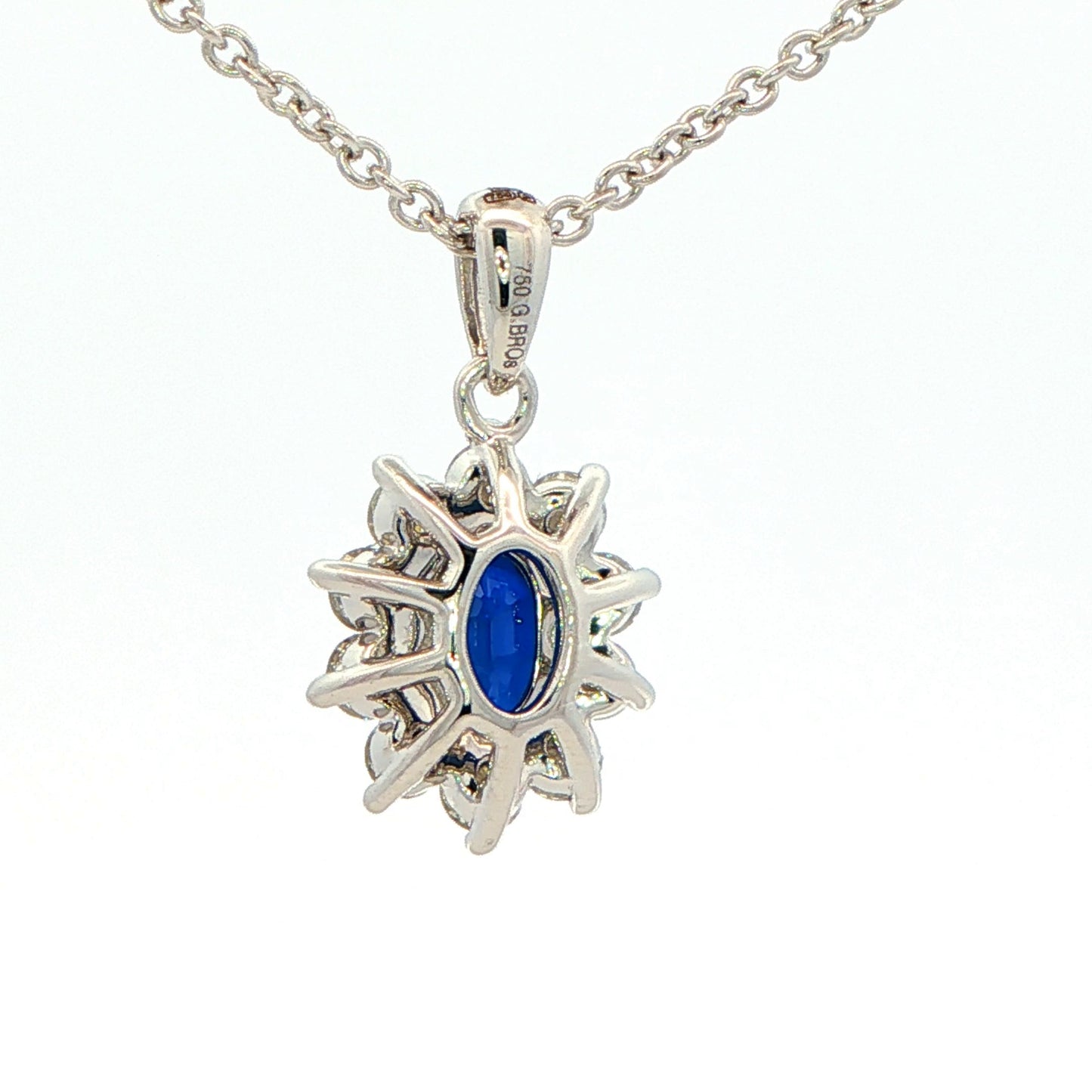 Oval shaped sapphire and round brilliant cut diamond cluster style pendant