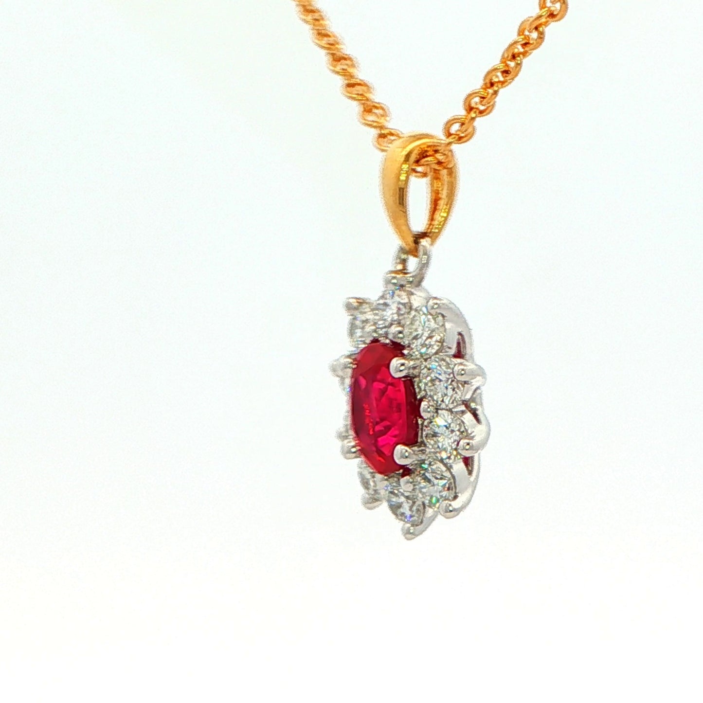 Oval shaped ruby and round brilliant cut diamond cluster style pendant
