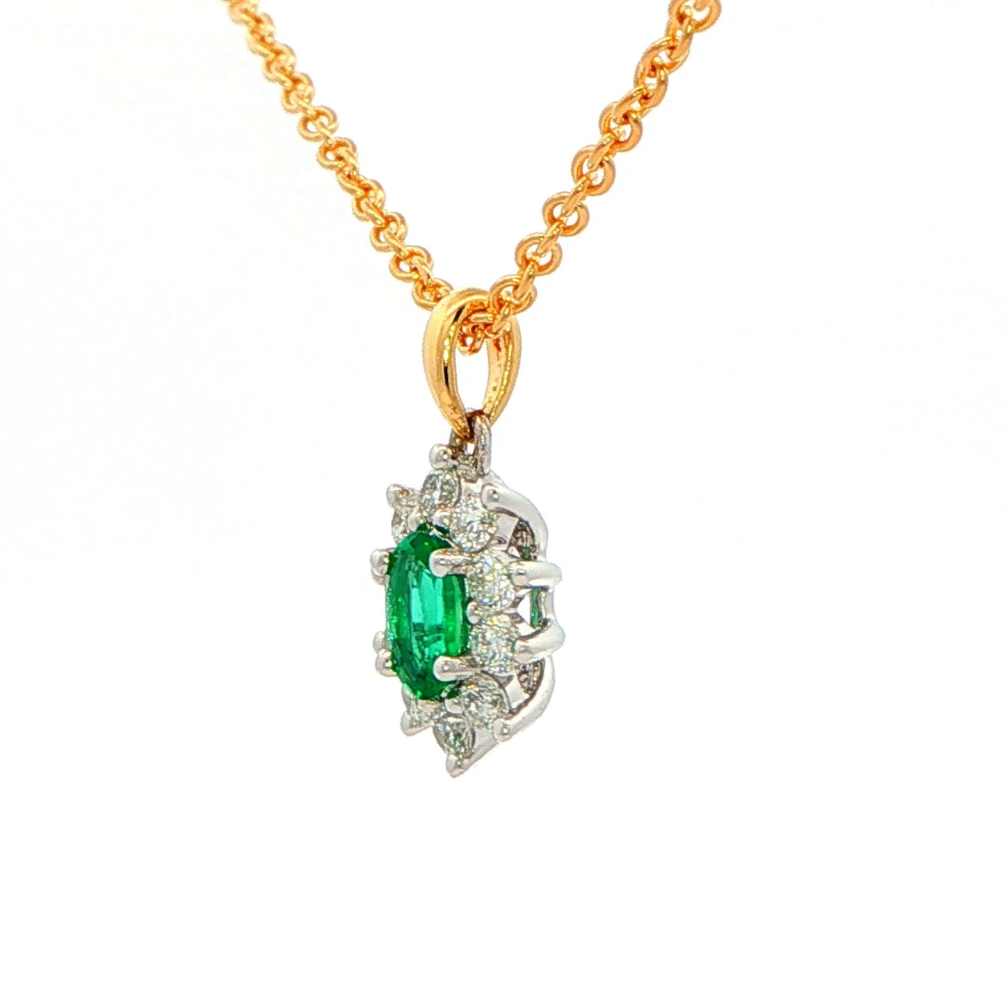 Oval shaped emerald and round brilliant cut diamond cluster style pendant