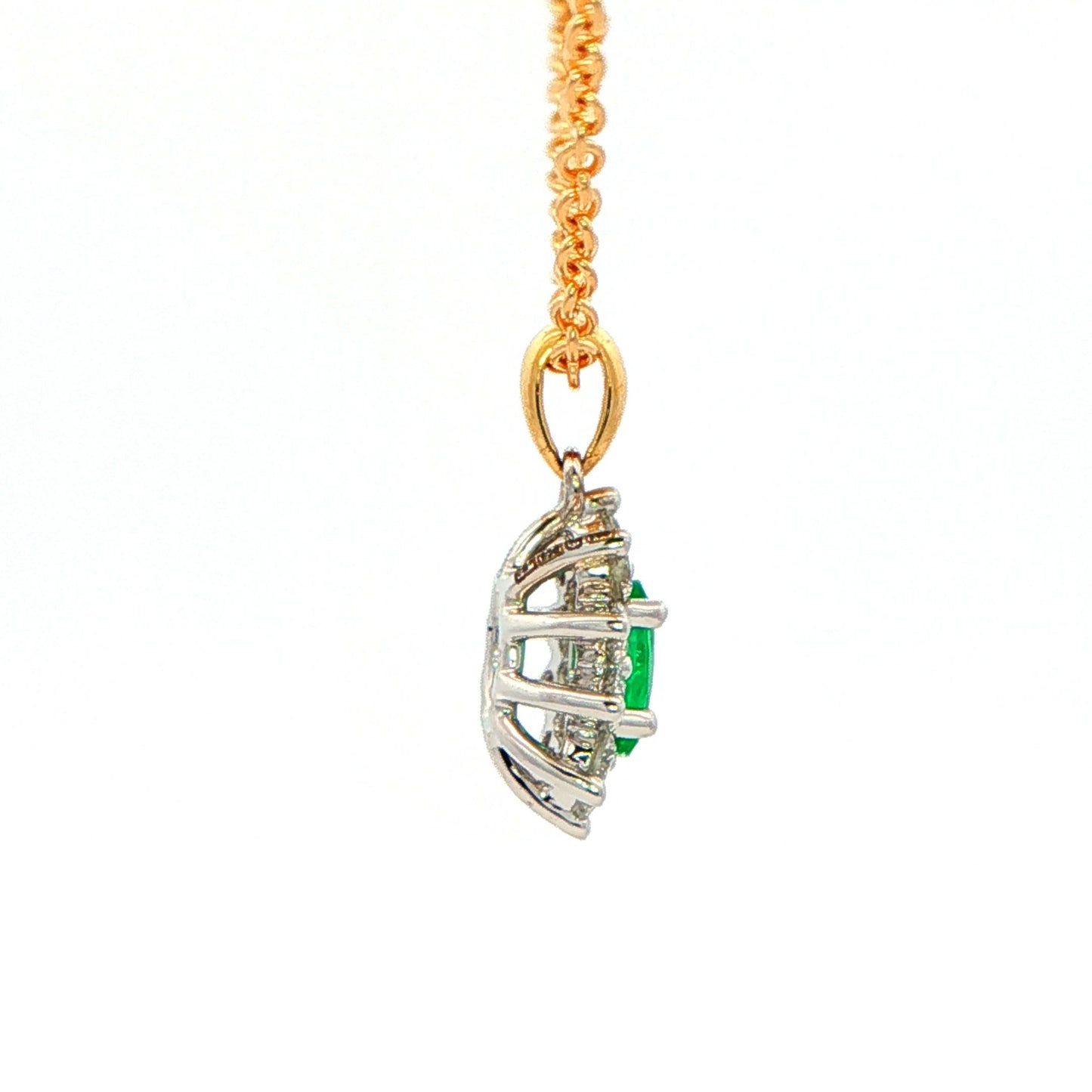 Oval shaped emerald and round brilliant cut diamond cluster style pendant