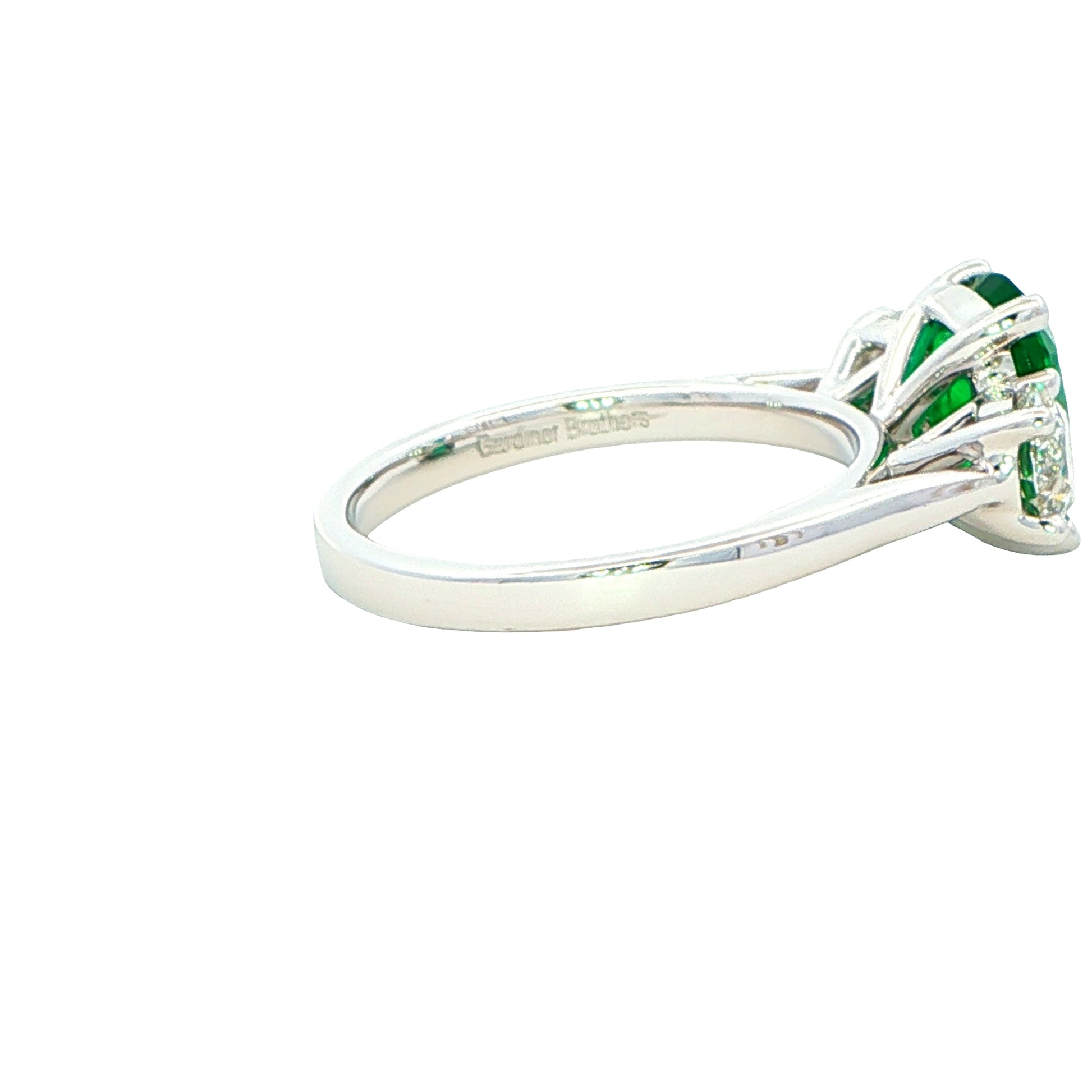Cushion shaped emerald and round brilliant cut diamond 3 stone ring Gardiner Brothers