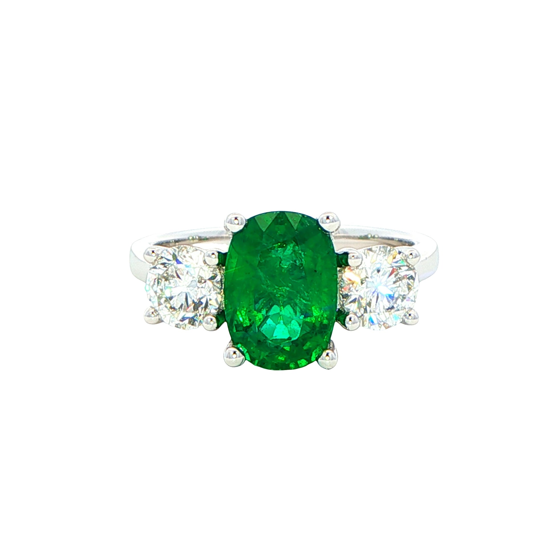 Cushion shaped emerald and round brilliant cut diamond 3 stone ring Gardiner Brothers