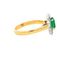 Oval Emerald and Round Brilliant Cut Diamond Cluster Ring